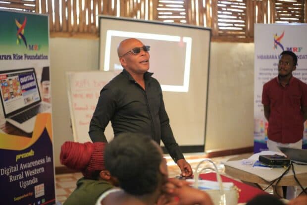 Person wearing a black shirt and black sunglasses with three other people.