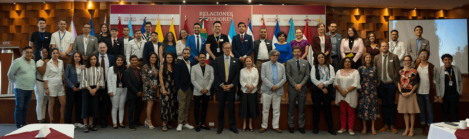 Large group photo of attendees at an LGBTIQ+ regional integration meeting with multiple country flags.