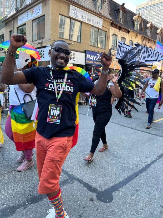 Person smiling and marching in a Pride parade.