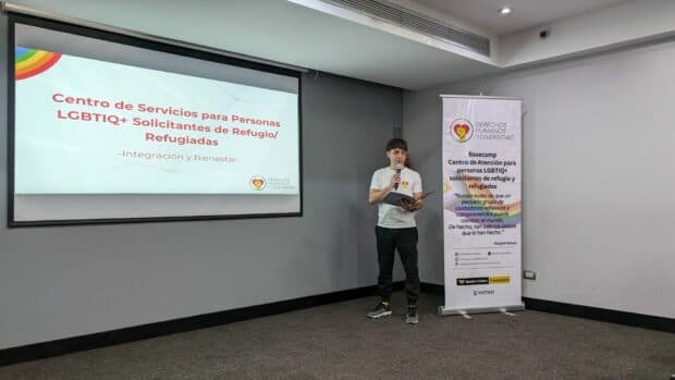 Person in a white shirt presenting with a banner beside them.