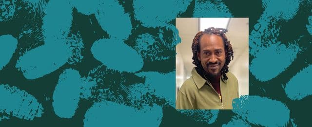 Portrait of a person smiling against a teal textured background.