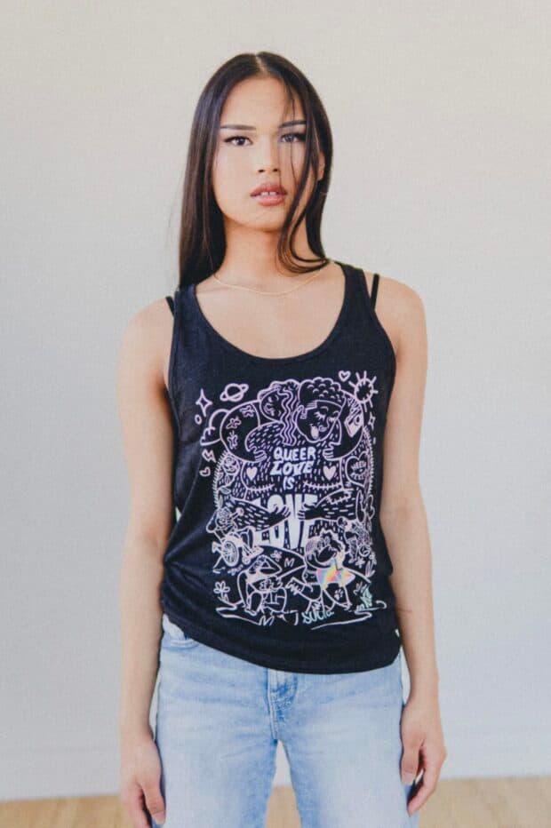 Person in a black tank top with a white illustrated “Queer Love” design.
