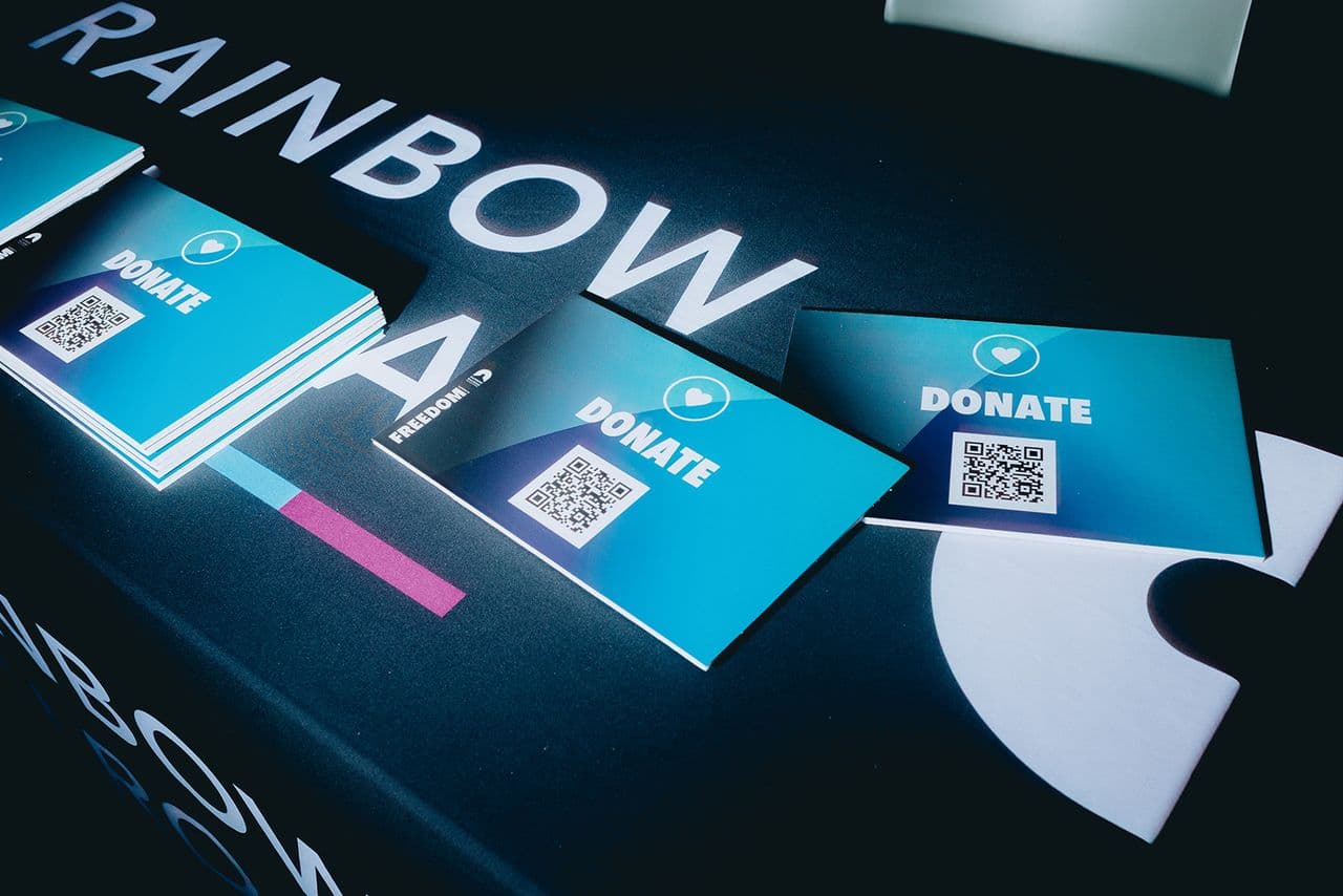 Donation QR codes on a table that says Rainbow Railroad